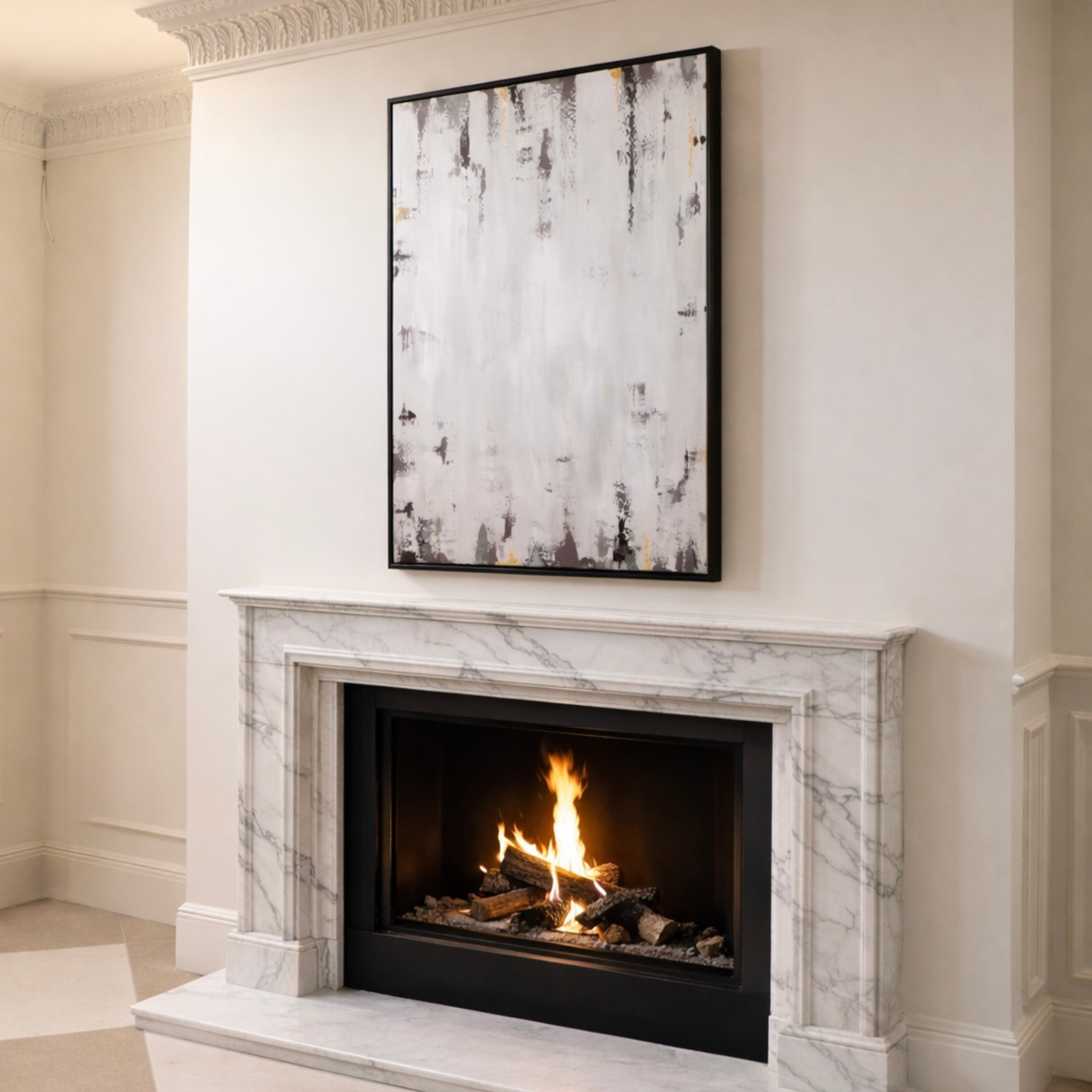 Marble fireplace with a lit fire and abstract painting above it in a room with cream walls.