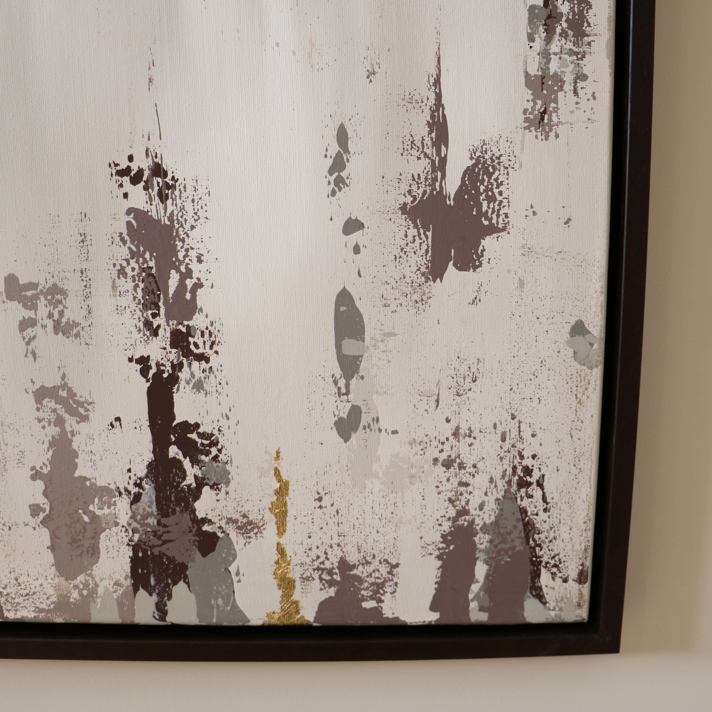 Abstract art piece with brown and gold splashes on a cream background