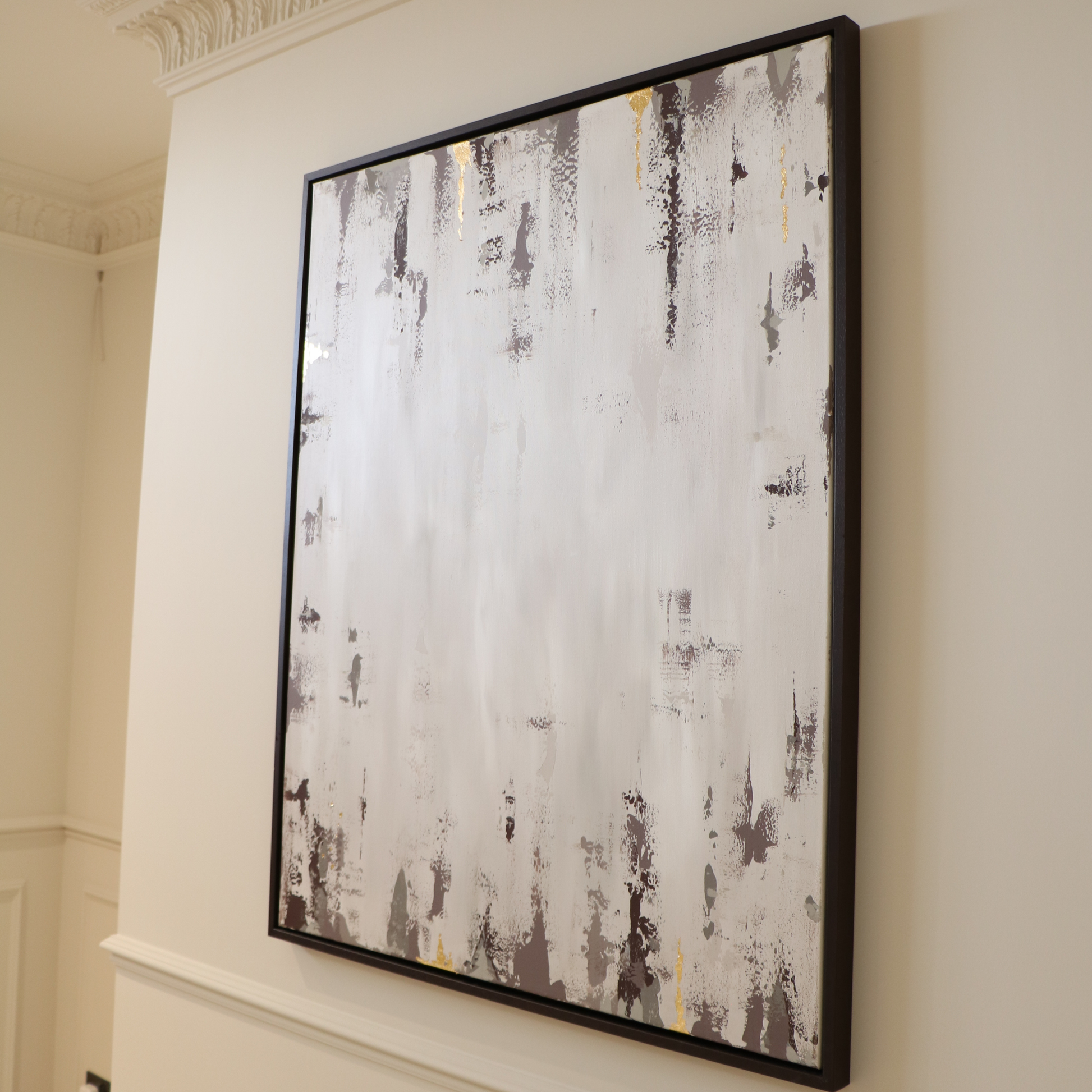 Abstract painting in a brown frame on a wall