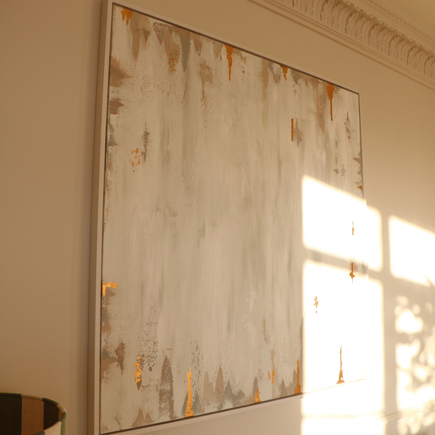 Abstract painting on a wall with sunlight casting shadows