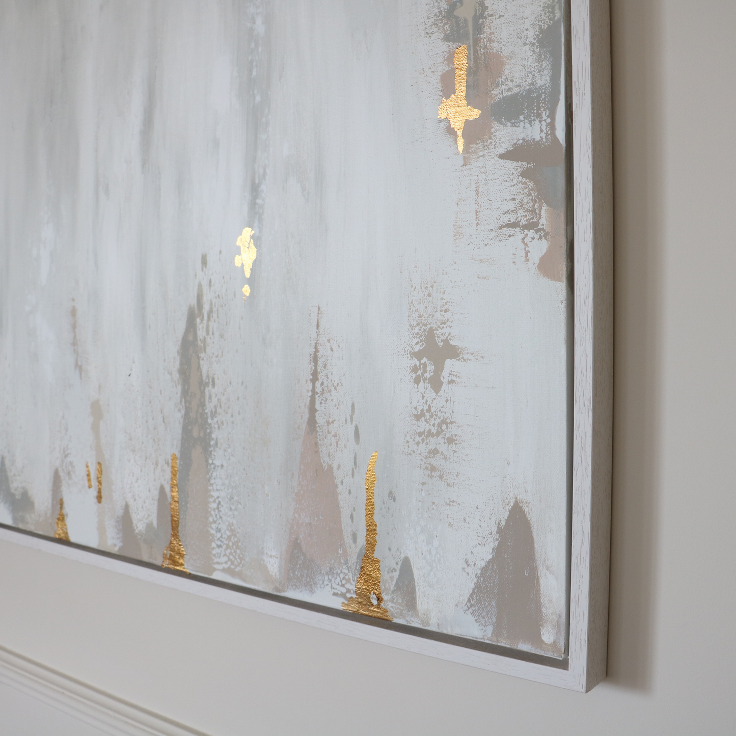 Framed abstract artwork with gold accents on a wall