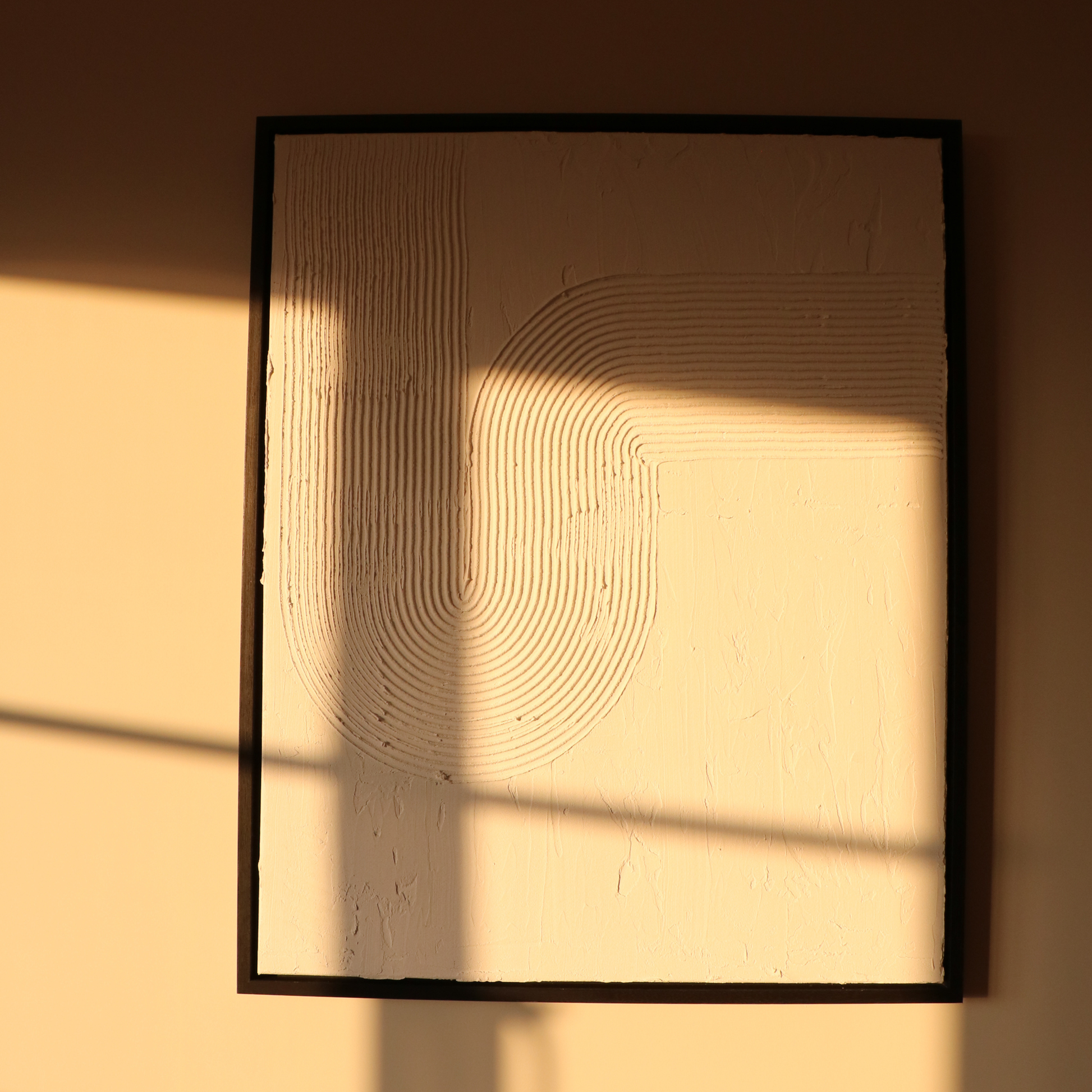 Framed abstract artwork with wavy lines on a textured white background